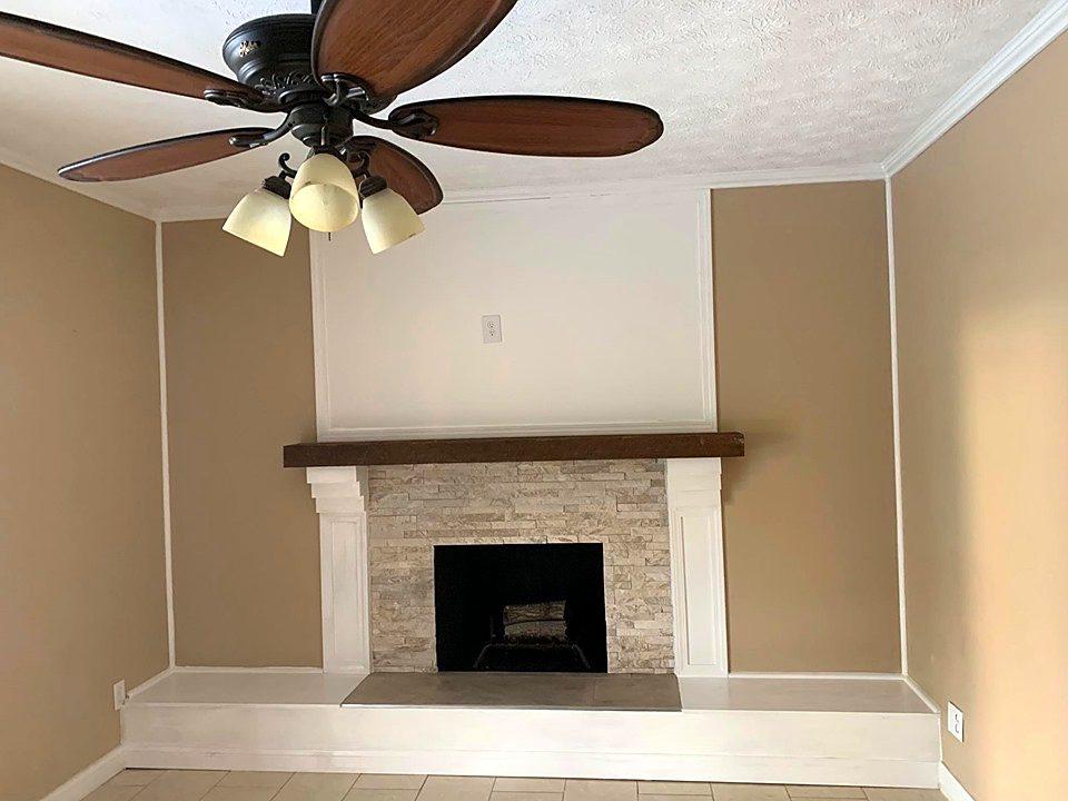 Fireplace makeover with white built-in surround, stone tile and stained wood mantel